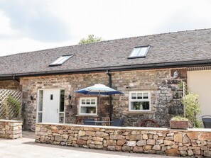 A stone building with a tiled roof, a door, and a window. - Sunbird Cottage (Stoke-on-Trent)