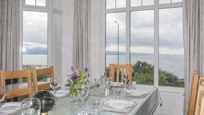 A dining table set for six with a view of the sea and mountains. - Llys Owen (Criccieth)