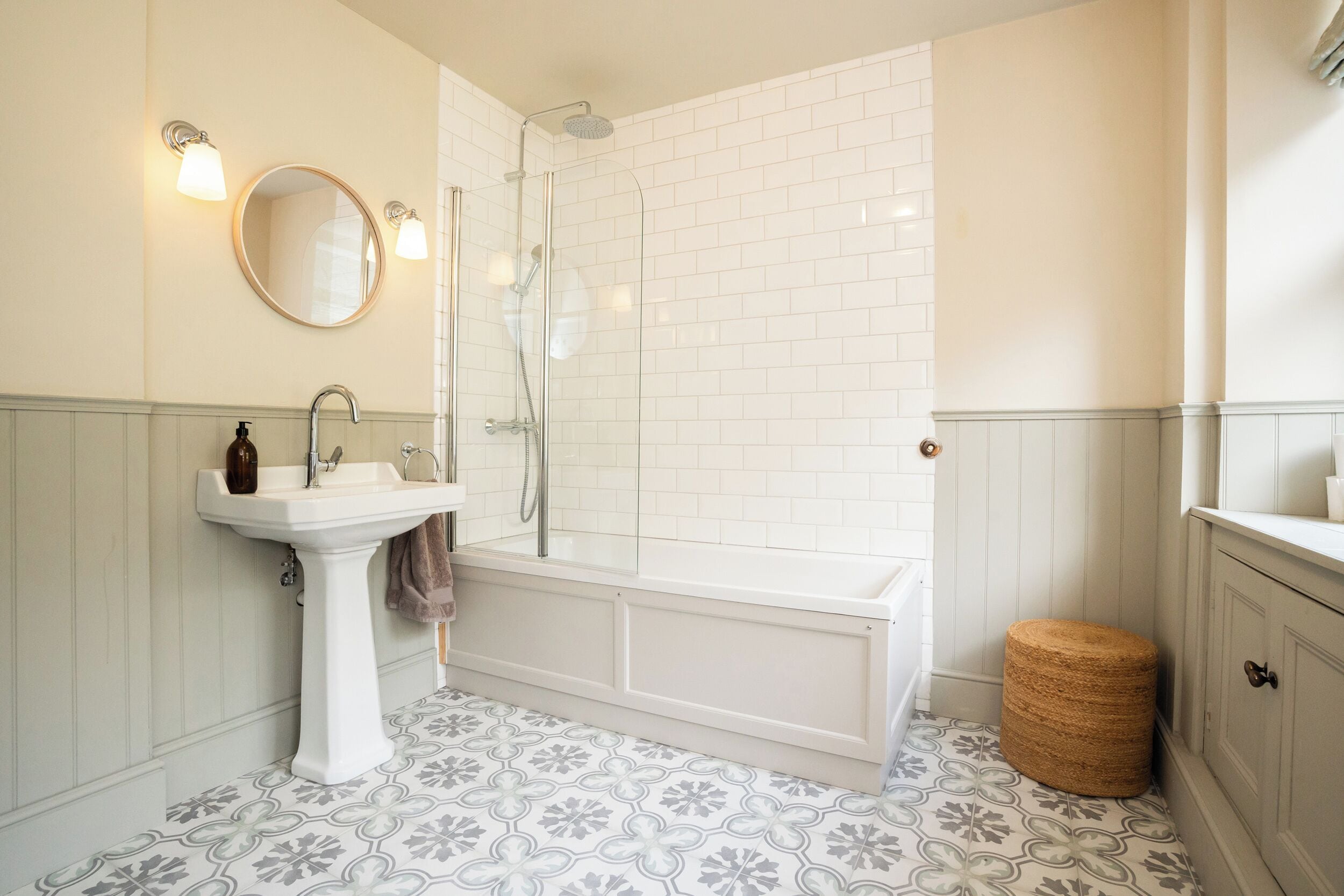 Un baño con lavamanos blanco, espejo y bañera.