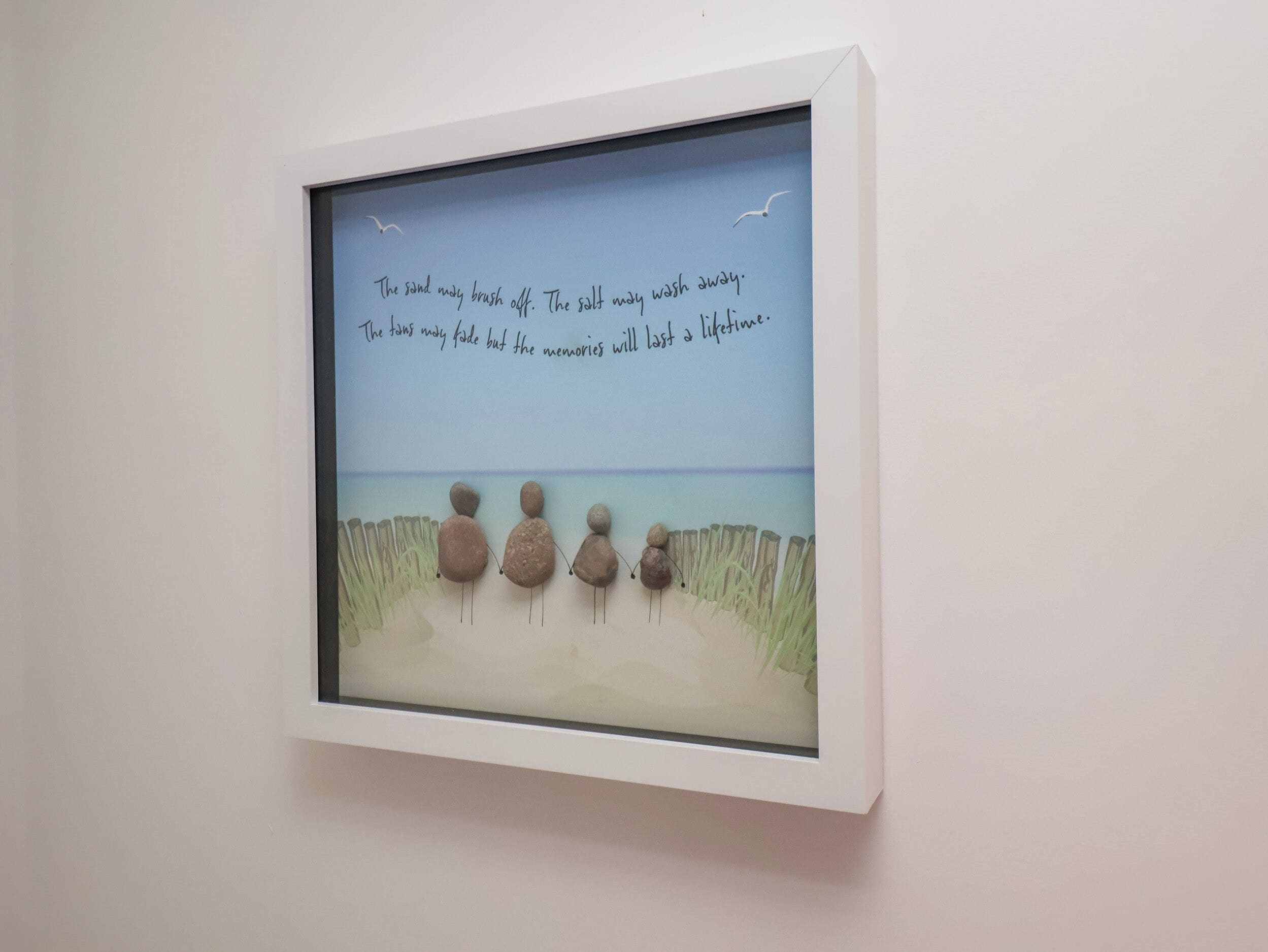 Obra enmarcada que muestra una escena de playa con una cita sobre recuerdos y el tiempo.