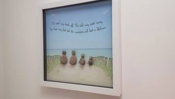 Obra enmarcada que muestra una escena de playa con una cita sobre recuerdos y el tiempo.