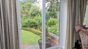 Quarto com porta de vidro deslizante que dá para um jardim.