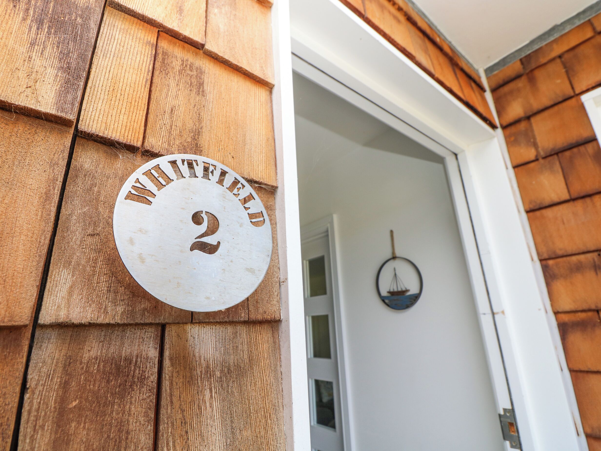 A wooden exterior with a circular sign reading "WHITFIELD 2".