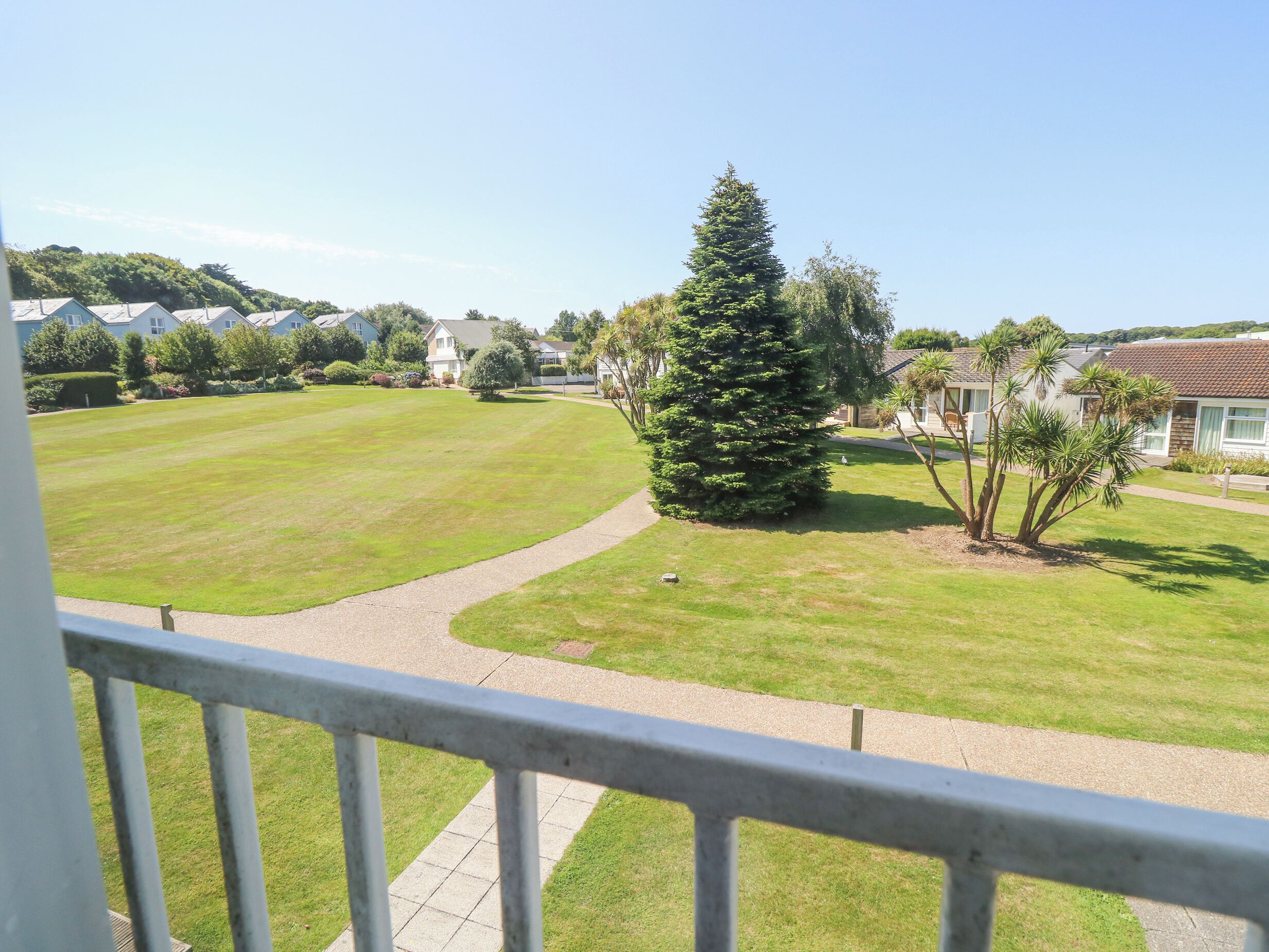 A residential area with houses, a large lawn, and a pathway.