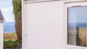 A white building with a window overlooking a coastal landscape. - Fifty Degrees North (Penzance)