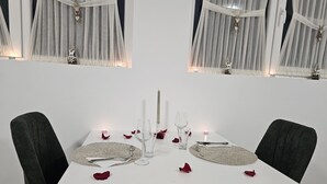 A dining table set for two with candles, glasses, and a centerpiece. - SKY DOME (Berinta)