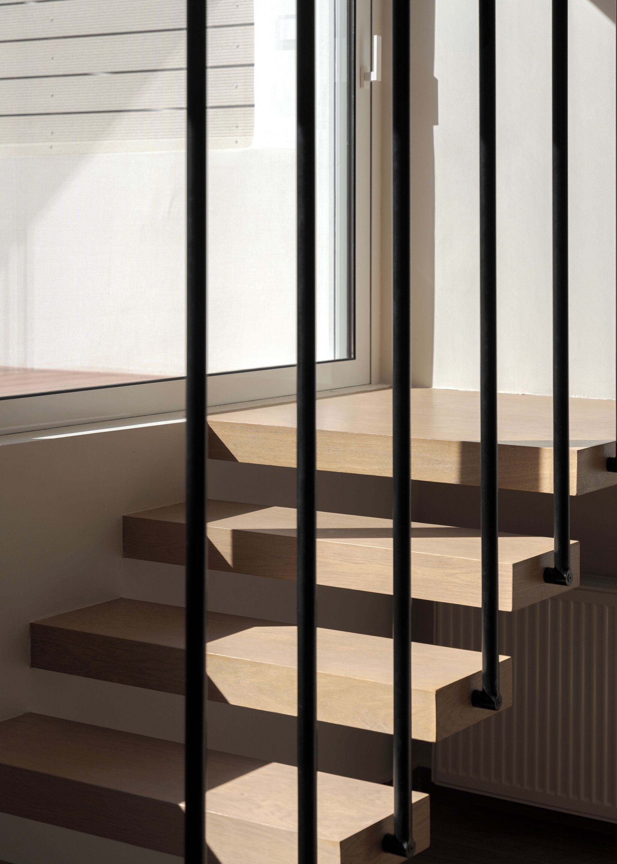 A staircase with wooden steps and black metal railings.