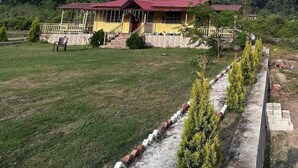 A building with a red roof, a yellow facade, and a small porch. - River View Bamboo Resort (Lansdowne)