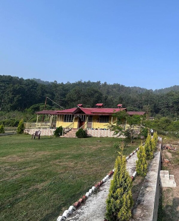 A building with a red roof, a yellow facade, and a small porch. - River View Bamboo Resort (Lansdowne)