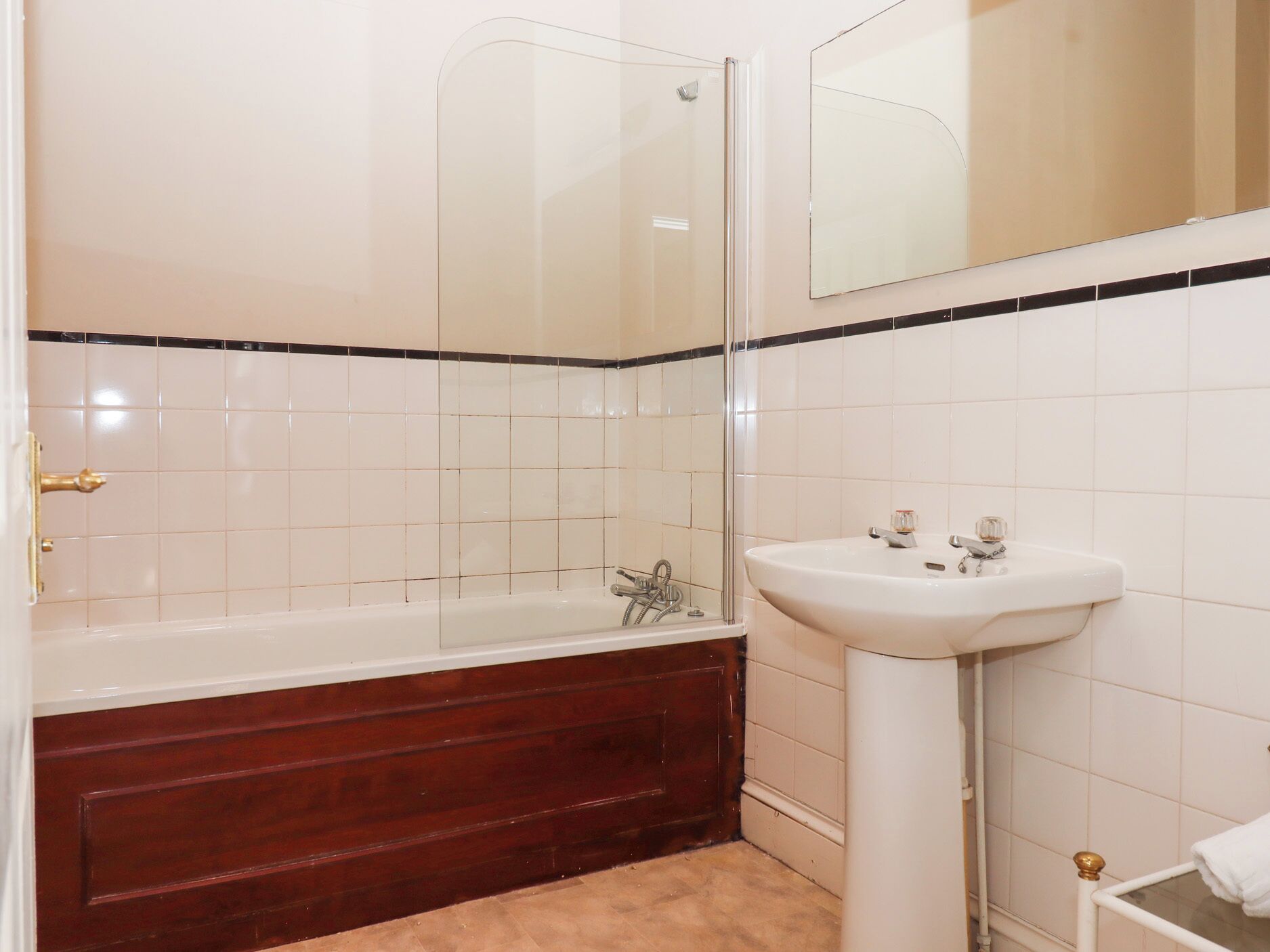 A bathroom with a bathtub, a sink, and a glass shower enclosure.
