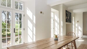 Una habitación amplia con un gran mesa de madera, una silla y un cuadro en la pared.