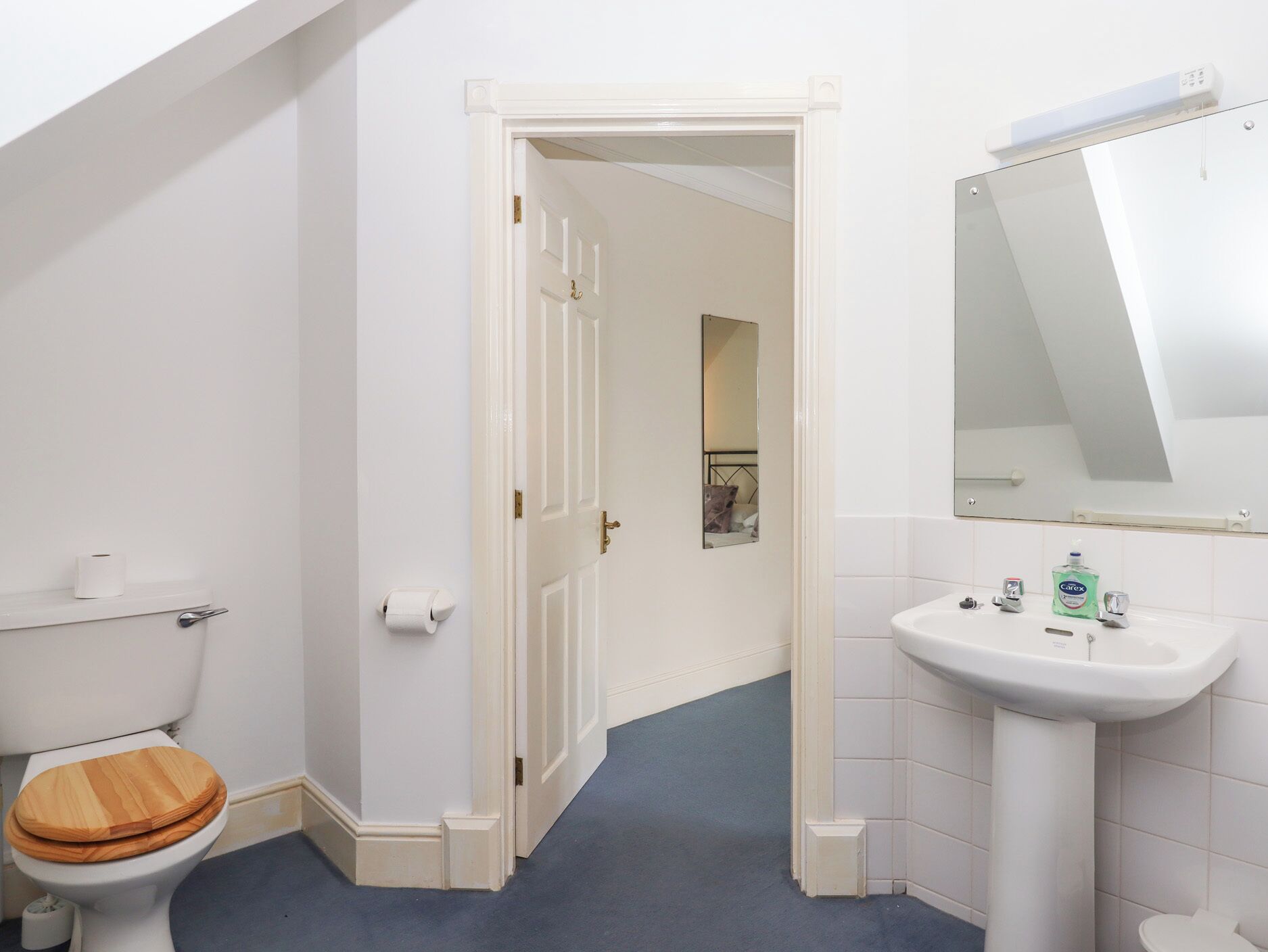Ein Badezimmer mit Toilette, Waschbecken und Spiegel.