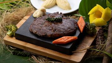 A steak with vegetables on a wooden board.