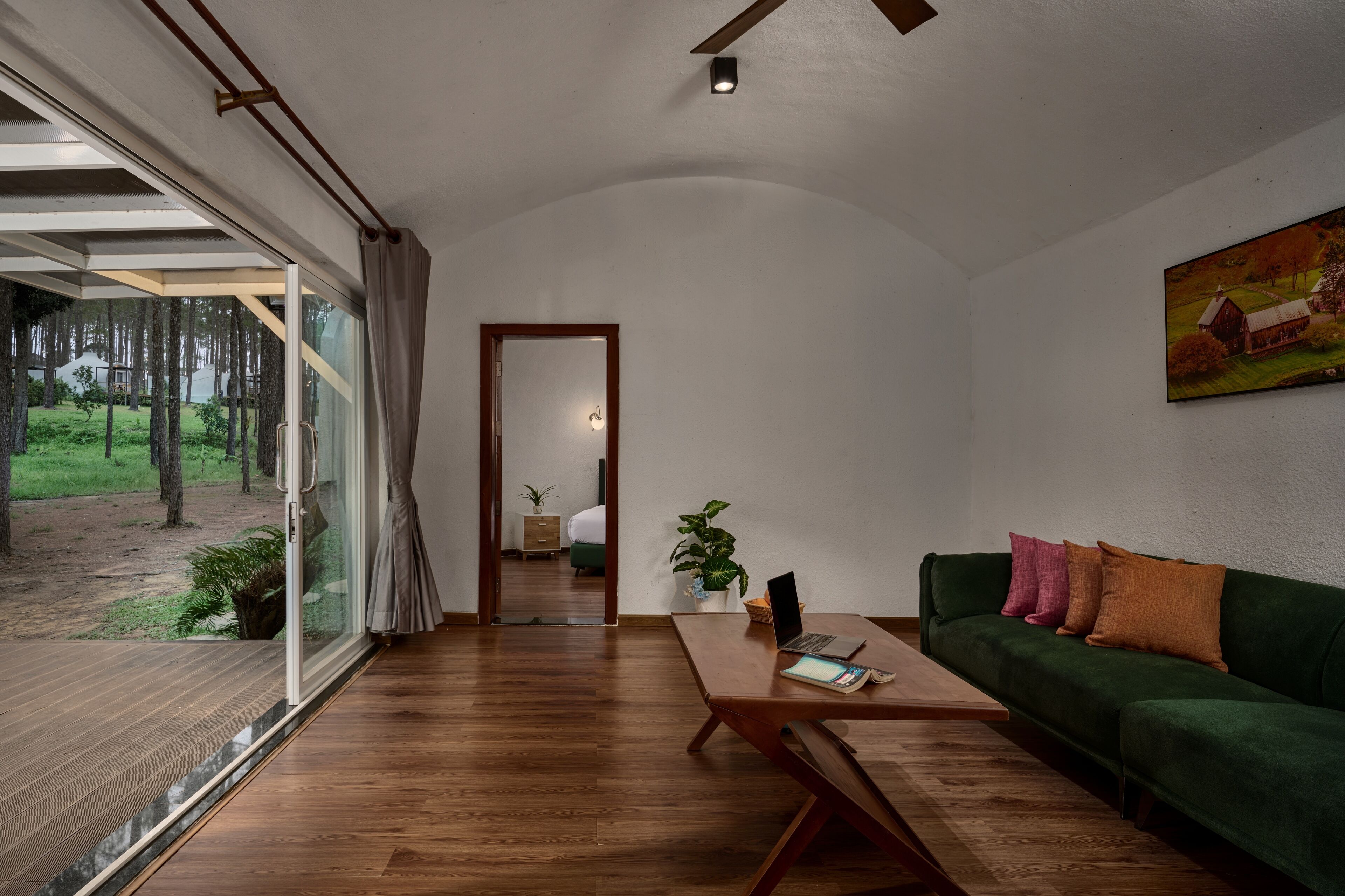 Una sala de estar moderna con un sofá verde, una mesa de centro de madera y un cuadro en la pared.