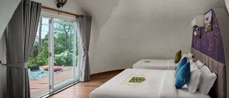 A bedroom with a bed, a desk, and a window with curtains.