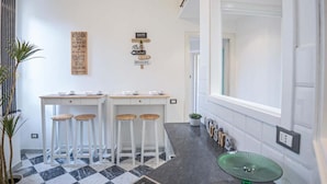 Una cocina con dos taburetes, una mesa baja y un letrero en la pared.
