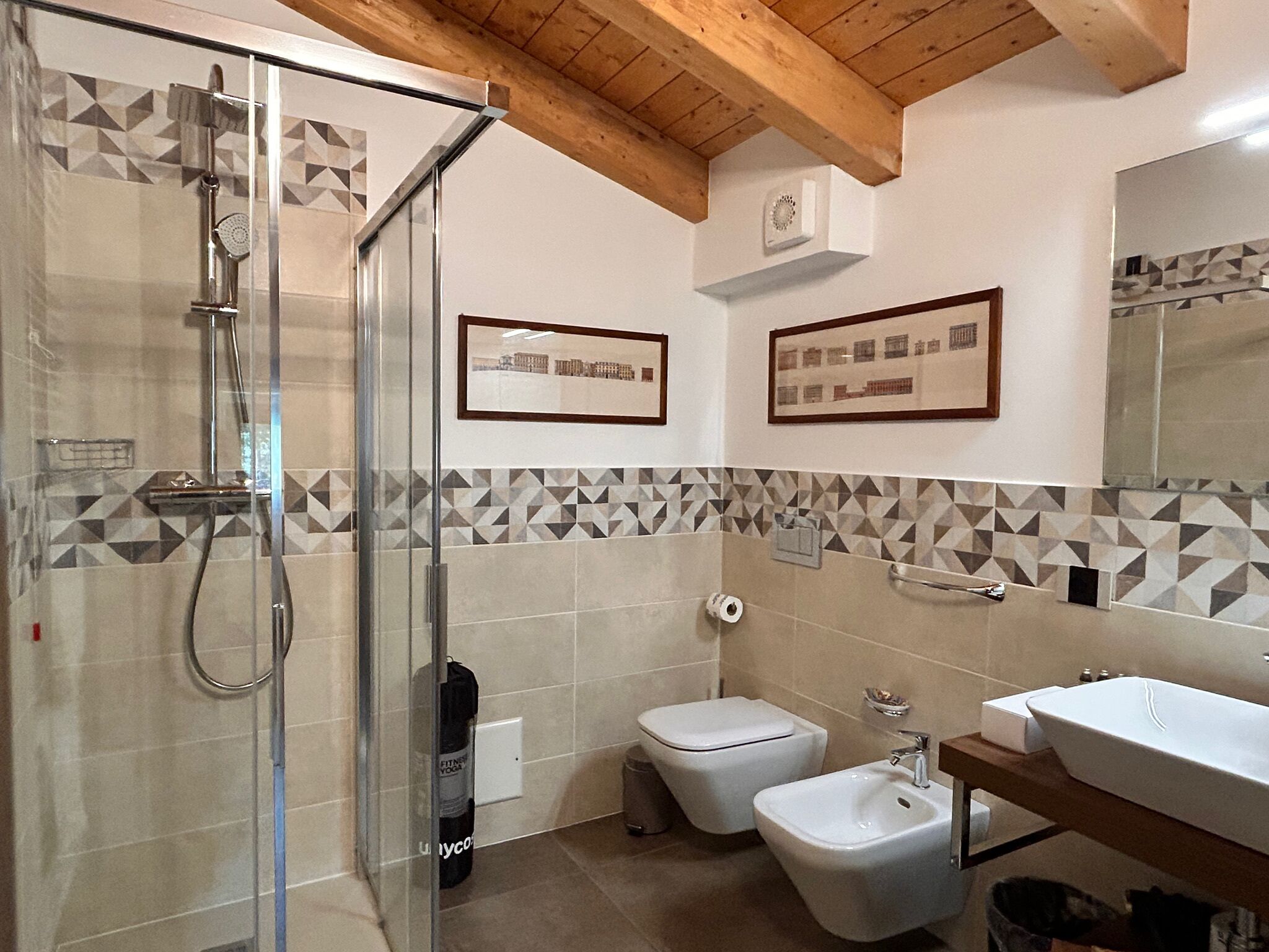 Un baño con cabina de ducha de vidrio, inodoro, bidé y lavabo.