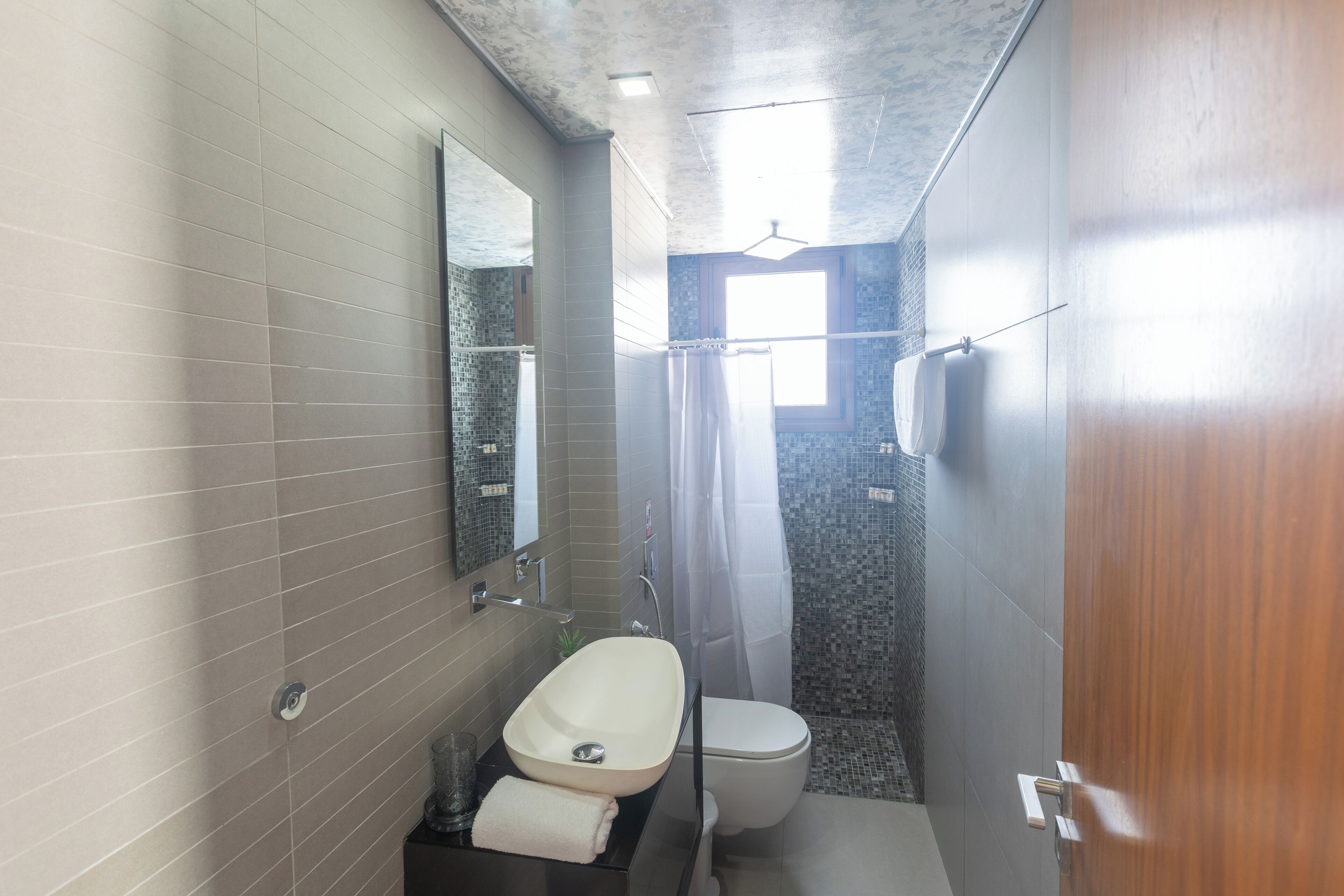 A bathroom with a white sink, toilet, and shower curtain.
