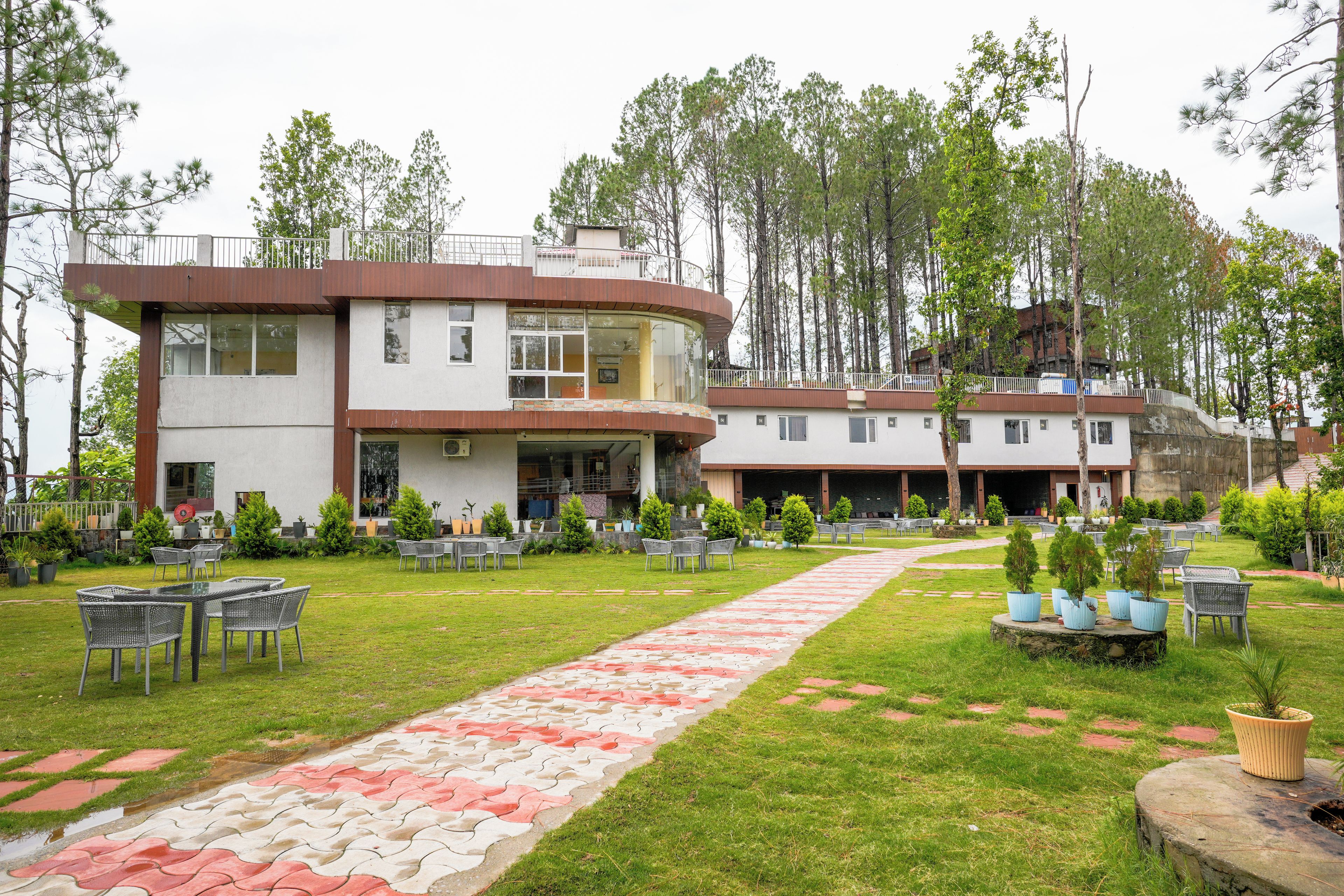 A hotel with a central courtyard, outdoor seating, and a building with multiple floors and balconies.