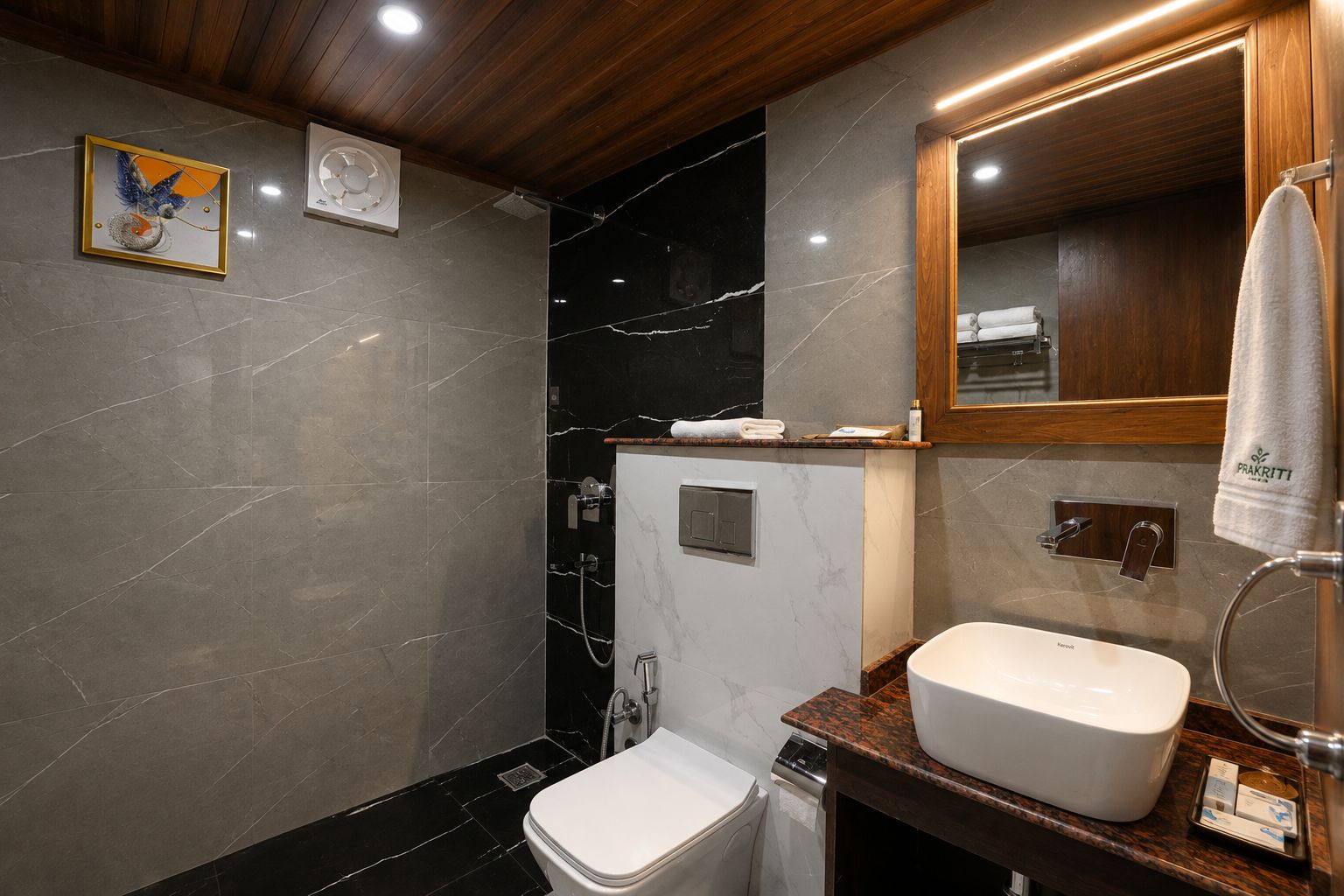 A modern bathroom with a marble wall, a white toilet, a sink with a wooden countertop, and a towel hanging on a rack.