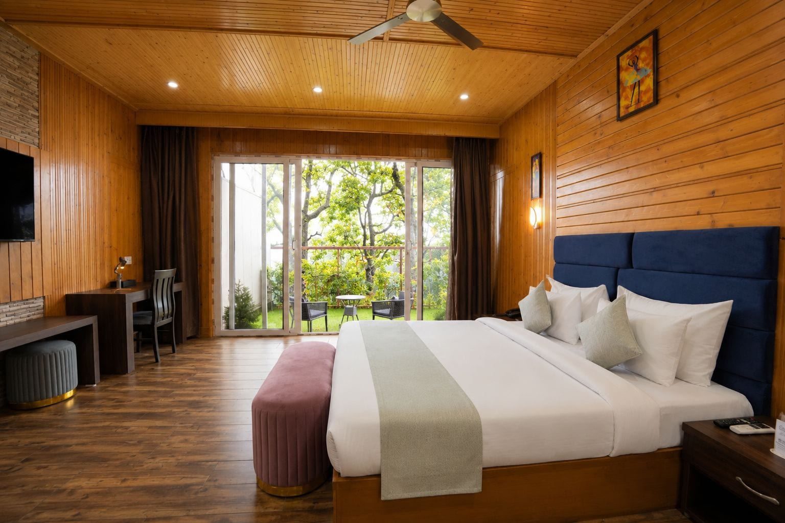 Habitación de hotel con una cama grande, un escritorio y vistas al exterior.