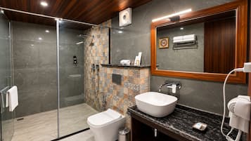 Une salle de bain moderne dotée d’une douche à parois de verre, de toilettes blanches, d’un lavabo avec un plan de travail en marbre et d’un miroir avec un cadre en bois.