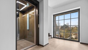 Um elevador moderno com design elegante e uma grande janela no lado direito.
