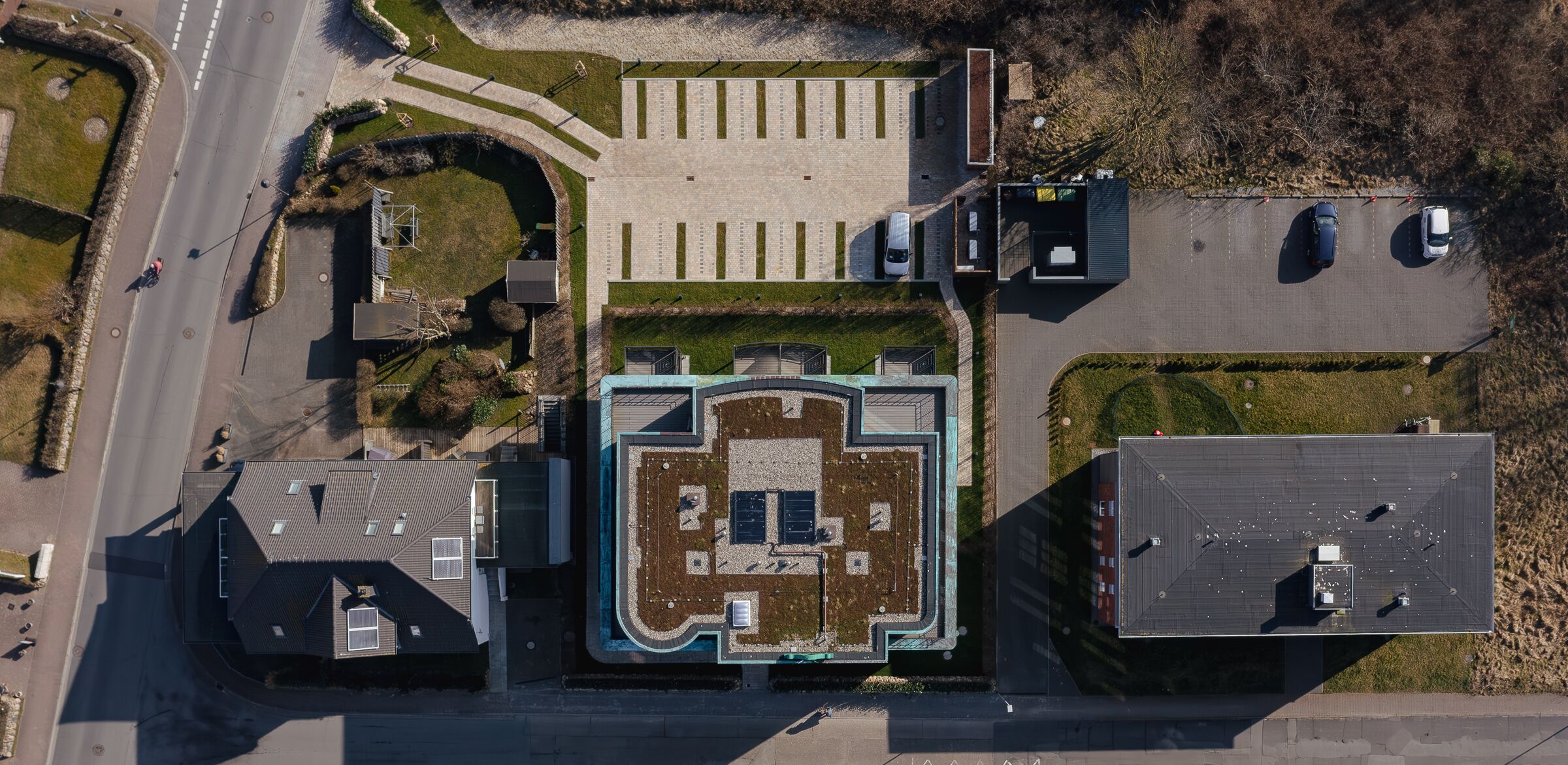 Ett flygbildsfoto av en byggnad med en central innergård, en parkeringsplats och angränsande byggnader.