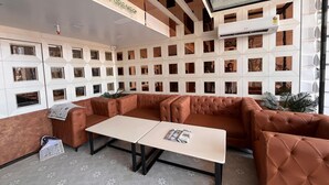Ein modernes Interieur mit einer Eckcouch, einem kleinen Tisch und einem gemusterten Boden.