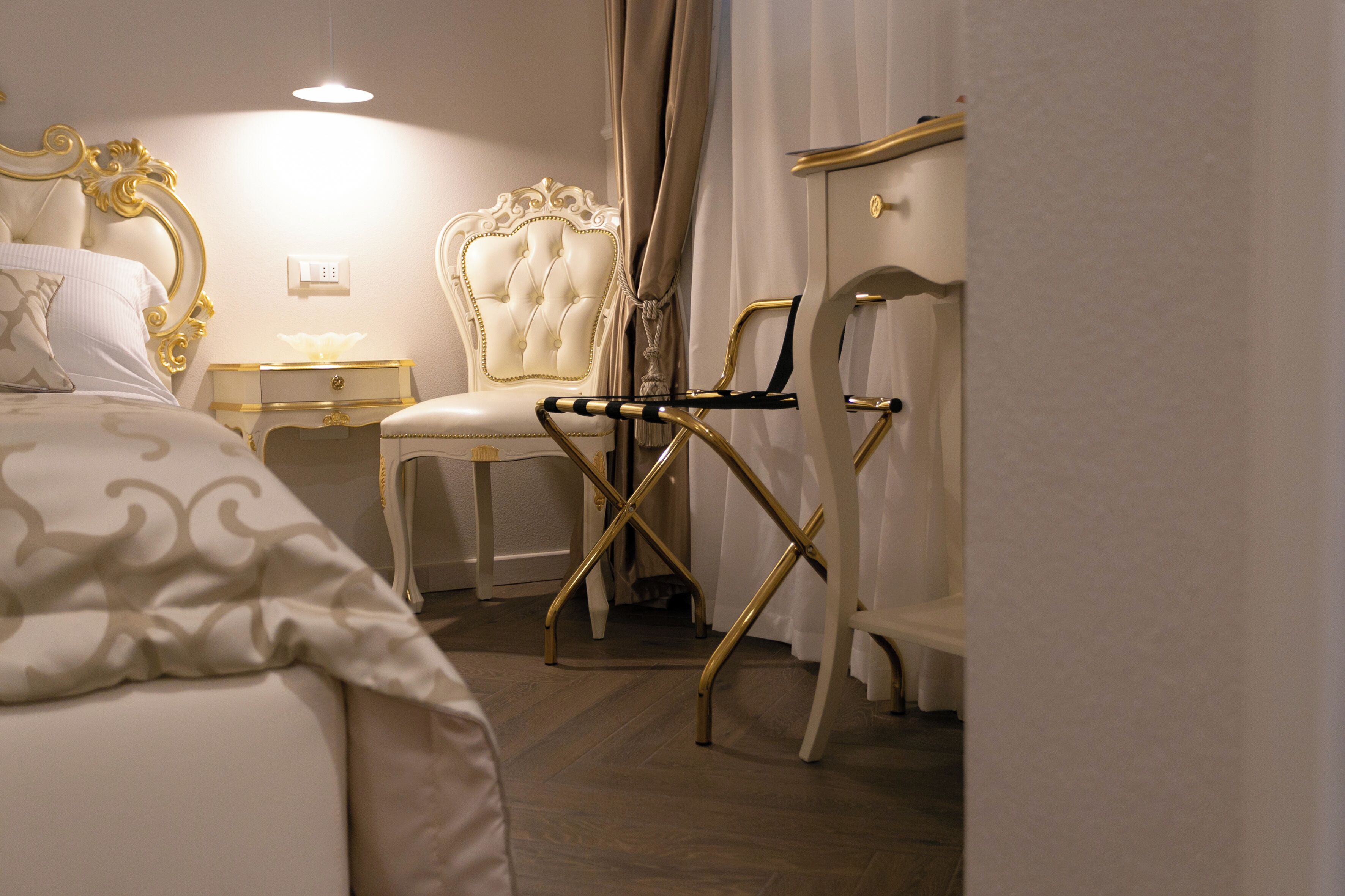 Una habitación de hotel con una cama, un tocador con espejo, una silla y un escritorio.