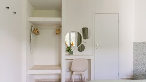 Une chambre à coucher avec un lit, un bureau, une chaise, une armoire et une porte.