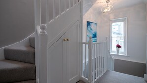 A staircase with white railings and a light fixture above. - Green Retreat (Dartmouth)