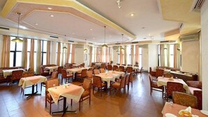 A spacious dining area with multiple tables and chairs, large windows, and a high ceiling with recessed lighting. - Red Bishop Tourist Complex (Panchkula)