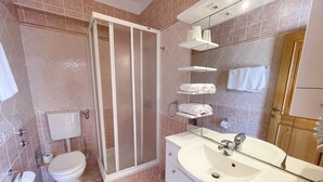 Un baño moderno con inodoro, ducha y lavamanos.