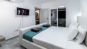 A bedroom with a bed, a TV, a sofa, and a wardrobe. - Vigla Kiotari - B, Villa (Greece)