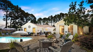Un jardin avec une piscine, un espace salon extérieur et une maison dotée d’une grande fenêtre.
