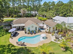 A residential property with a swimming pool, outdoor seating, and a fenced backyard. - Single Level Home, Private Backyard Oasis with Heated Pool, 4 BR, Bikes & Pond (Santa Rosa Beach)