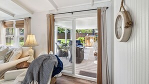 Une pièce confortable avec un lit, une chaise, une table et une vue sur la terrasse extérieure.