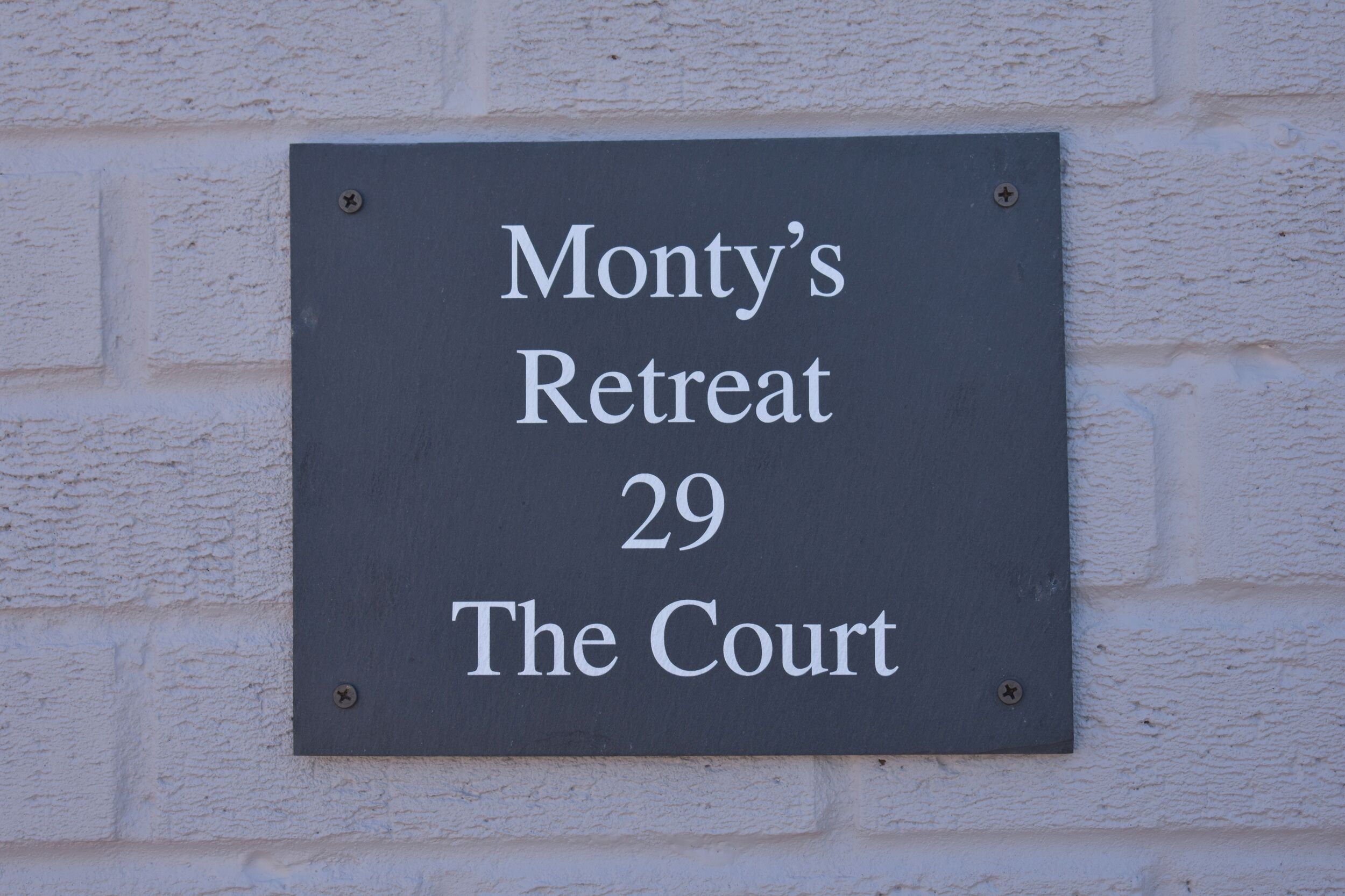 Une enseigne portant l’inscription « Monty’s Retreat, 29, The Court ».