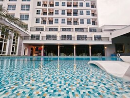 A hotel with a large pool area featuring a mosaic tile design.