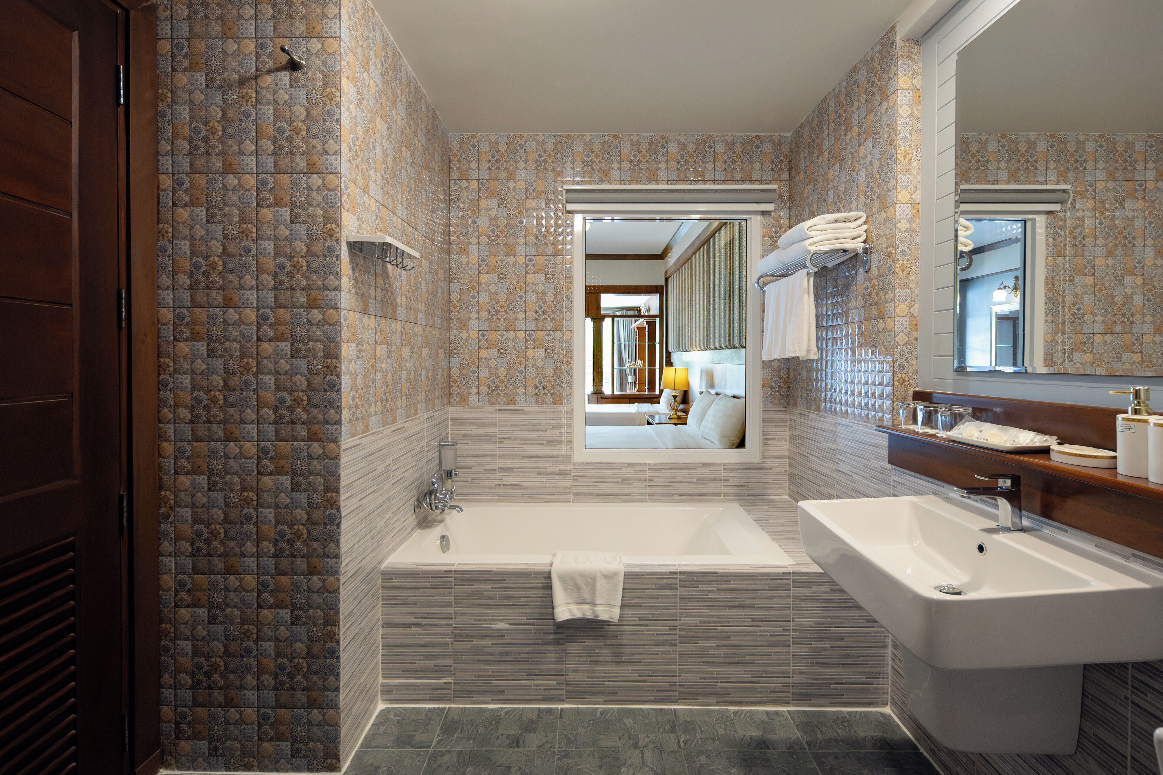 Un baño moderno con una bañera, un lavabo y un espejo.