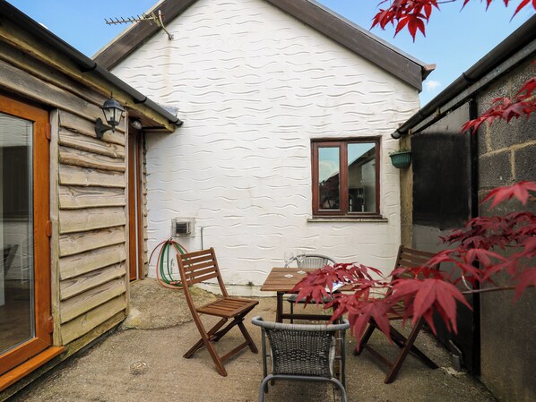 A wooden house with a white exterior, a window, and a door.