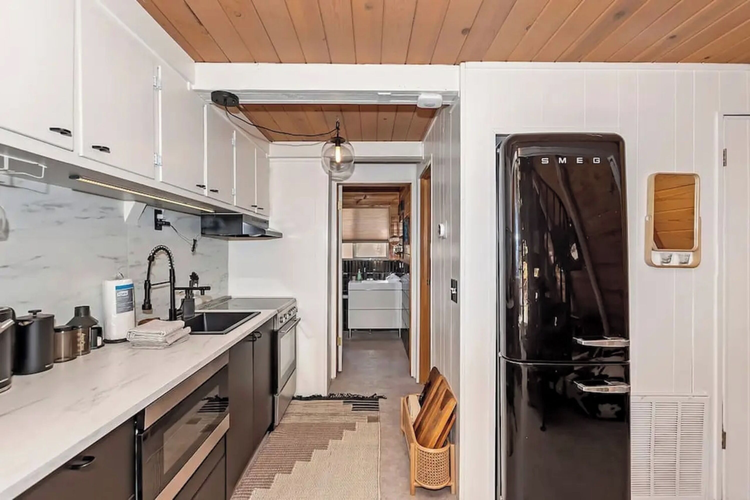 Eine moderne Küche mit Einbauofen, Kühlschrank und Holzboden.