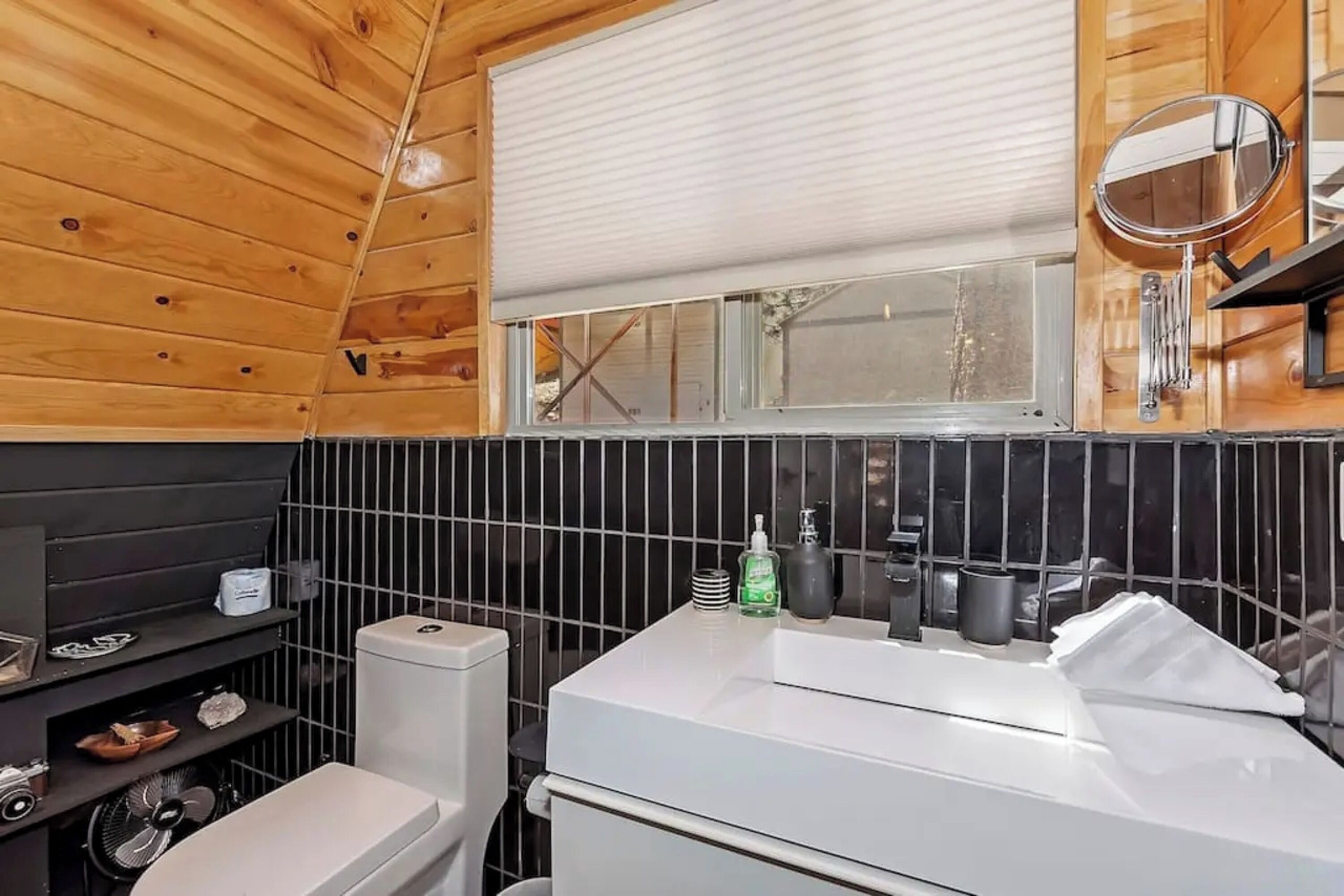 A compact bathroom with a toilet, sink, and window.