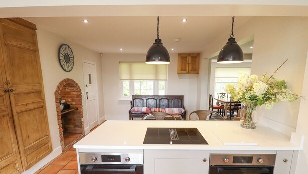A kitchen with a central island, double ovens, and hanging pendant lights. - Moon Field Lodge (Scunthorpe)
