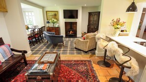 A cozy living room with a fireplace, a coffee table with books, and a patterned rug. - Moon Field Lodge (Scunthorpe)