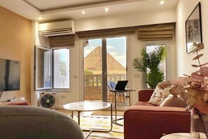 Basic Apartment | Living area | 55-inch Smart TV with satellite channels - Xuru Stays I Spellbinding 2 BDR Apt. At The Giza Pyramid's Doorstep (Giza)