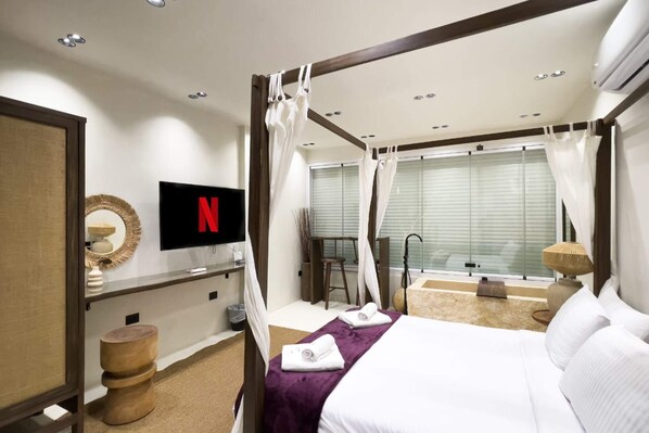 A modern hotel room with a canopy bed, a flat-screen TV, a minibar, and a view of the outdoors. - Xuru Stays I The Pyramids Horizon Studio w/ Bathtub (Giza)