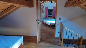 A wooden loft bedroom with a sloped ceiling, a single bed, and a small window with checkered curtains. - Tobleralpe cozy self-catering hut in the Allgäu / Oberreute near Oberstaufen (Oberreute)
