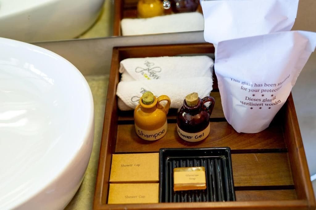 A tray with toiletries including shampoo, shower gel, and a bottle of shampoo.
